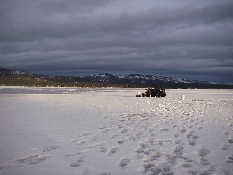 Montana winter ice fishing four wheeler pulling sled on ice Montana winter ice fishing four wheeler pulling sled on ice