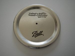 Canning jar lid being turned into a DIY soap lotion dispenser