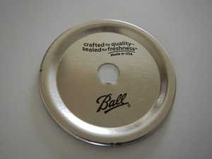 Drilling a hole in a canning jar lid