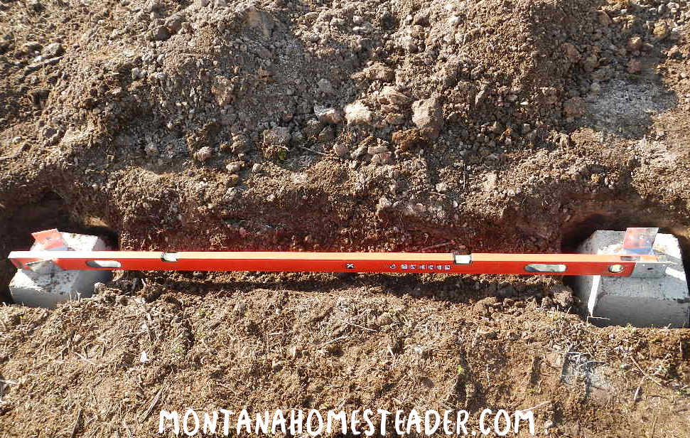How to anchor a greenhouse kit to the ground using concrete pier supports bolted to lumber making sure the base is square and level