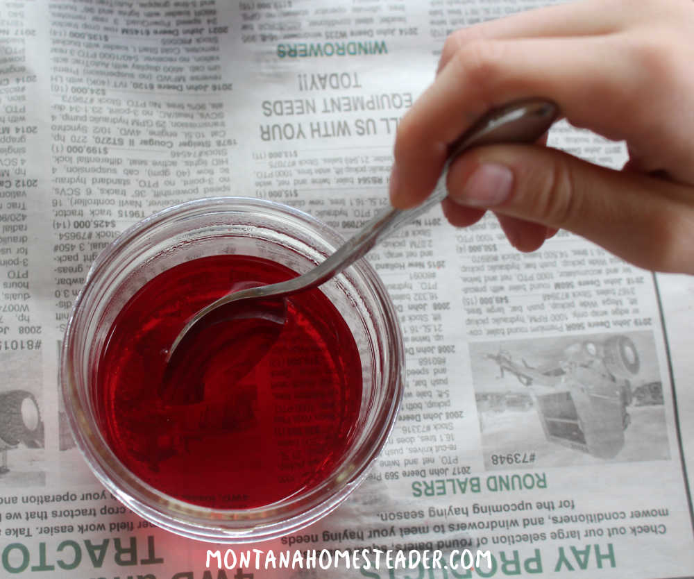 How to dye blown eggs with food coloring how to make egg dye with food coloring and vinegar stirring boiling water food coloring and vinegar in wide mouth jar over newspaper on a table