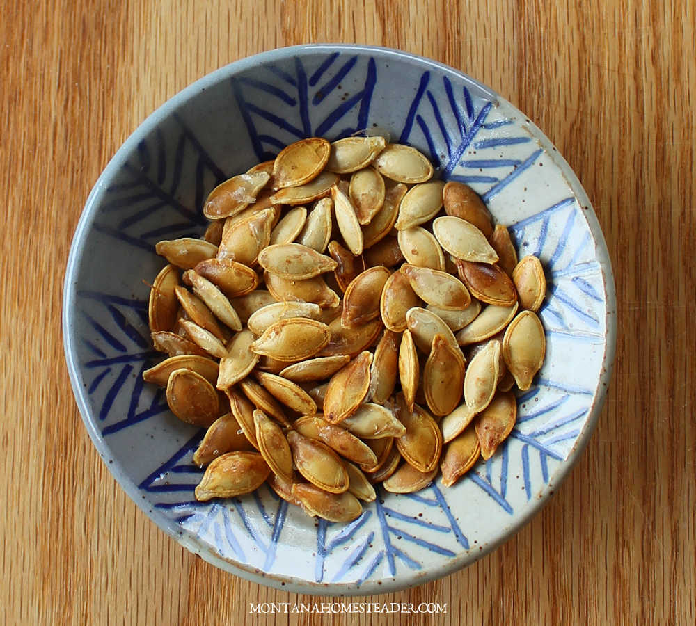 How to make salted roasted pumpkin winter squash seeds blue ceramic bowl with roasted salted pumpkin seeds on wood board